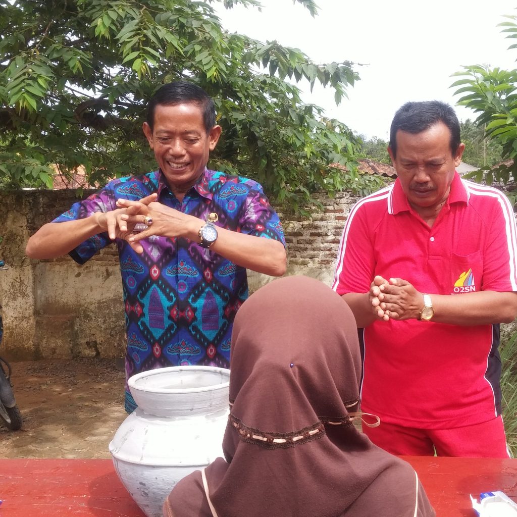 KUPTD Pendidikan Kecamatan Katibung Surono didampingi Kepala Sekolah SDN 2 Tanjung Ratu Hi. Muhammad S.Pd mencontohkan cara mencuci Tanggan dengan baik dan benar